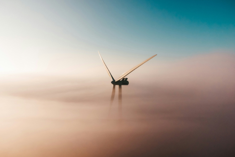 A wind turbine partially obscured by mist